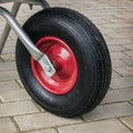Detail of garden wheelbarrow. Wheel with a red disk Royalty Free Stock Photo