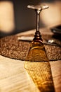 Detail of glass on wooden table of luxurious restaurant with shadows of natural light Royalty Free Stock Photo