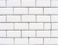 Detail of a glossy white beveled tile wall with damage Royalty Free Stock Photo