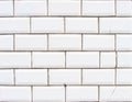 Detail of a glossy white beveled tile wall with damage