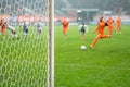 Detail of goal's post with net and football player during penalty kick Royalty Free Stock Photo