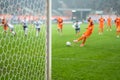 Detail of goal's post with net and football player during penalty kick Royalty Free Stock Photo