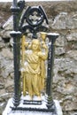 Detail of the gold colored metal figure of saint man