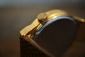 Detail of a golden watch with indented gold-plated crown as a symbol of time or exactness Royalty Free Stock Photo