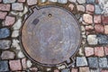 Detail of granite street paving stones in blue and brown colors. Old manhole cover Royalty Free Stock Photo