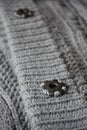 Detail of gray buttons fastening the woolen sweater