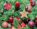 Detail of green Christmas tree with colored ornaments, globes, stars Royalty Free Stock Photo