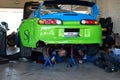 Detail of a green Toyota Supra in the pits in the garage