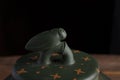 Detail of green traditional chinese Yixin clay teapot with cicada on the cover. On the wooden table and black backround Royalty Free Stock Photo