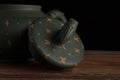 Detail of green traditional chinese Yixin clay teapot with cicada on the cover. On the wooden table and black backround Royalty Free Stock Photo