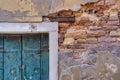 Detail with a green wooden shutter window on a worn out plastered red brick wall, in Venice Italy Royalty Free Stock Photo