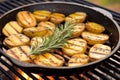 detail of grilled potatoes with rosemary in a copper pan