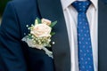 detail of a groom`s dark blue costume with a buttonhole of roses Royalty Free Stock Photo