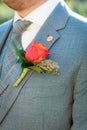 Detail of groom in wedding suite with coursage and 3 piece gray
