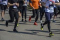 Detail of a group of runners during a city marathon. Legs and sneakers. Muscles under stress Royalty Free Stock Photo