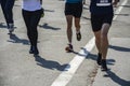 Detail of a group of runners during a city marathon. Legs and sneakers. Muscles under stress Royalty Free Stock Photo