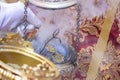 Detail of the hand of an altar boy or acolyte in a Holy Week procession filling one of the censers with incense