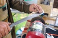 Detail: Hand of a Craftsman sharpens and grinds a machete with a grinder - selective focus with much blurred background