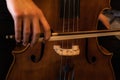 Detail of a hand holding a music bow to play a cello and to bring out the sound Royalty Free Stock Photo