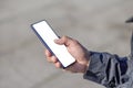 Detail of the hand of a Latin man holding a mobile phone with a blank screen Royalty Free Stock Photo