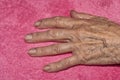 Detail of the hand of a 90 year old lady isolated on pink Royalty Free Stock Photo