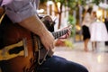 Detail of the hand of a young man playing an electro-acoustic rock guitar outdoors Royalty Free Stock Photo