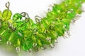 Detail of handcrafted plant like necklace from silver jewelry wire and green glass gems.