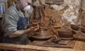 Detail of the hands of a clay artisan seen at his warehouse working on a vase