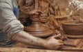 Detail of the hands of a clay artisan seen at his warehouse working on a vase