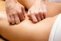 Detail of hands massaging female hamstring. Royalty Free Stock Photo