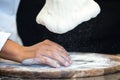 Detail of the hands of a pizza chef chef who works for the various stages of preparing a real Italian pizza homemade with yeast fl