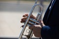 Detail of the hands of a trumpet player playing the musical instrument. The hand raises and lowers the pistons of the trumpet. Royalty Free Stock Photo