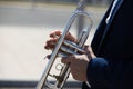 Detail of the hands of a trumpet player playing the musical instrument. The hand raises and lowers the pistons of the trumpet. Royalty Free Stock Photo