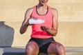 Detail of the hands of a young afro woman dressing sports clothes applying sanitizer gel