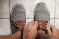 Detail of the hands of a young Brazilian man tying the tennis shoe Royalty Free Stock Photo