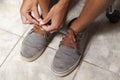 Detail of the hands of a young Brazilian man tying the tennis shoe Royalty Free Stock Photo