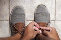 Detail of the hands of a young Brazilian man tying the tennis shoe Royalty Free Stock Photo