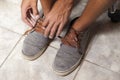 Detail of the hands of a young Brazilian man tying the tennis shoe Royalty Free Stock Photo