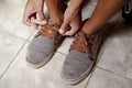 Detail of the hands of a young Brazilian man tying the tennis shoe Royalty Free Stock Photo