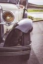 Detail of the headlight or front light and right wheel of a collector`s car from the early 20th century