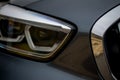 Detail of headlight from a modern car of european design. Metallic black paint Royalty Free Stock Photo