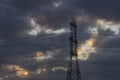 Detail of a high voltage power line pylon against a beautiful cloudy sky with the colors of dawn Royalty Free Stock Photo