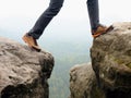 Detail of hiker legs in black orange hiking boots on mountain summit. Feet in trekking shoes Royalty Free Stock Photo