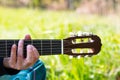 Detail Hippy man playing guitar outdoors on the grass Royalty Free Stock Photo