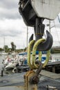 Detail of a hook attached to a construction crane in a port in Italy. Cloudy sky