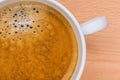 Detail of hot black coffee with foam bubbles in white cup with b Royalty Free Stock Photo