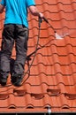 Worker cleaning metal roof with high pressure water Royalty Free Stock Photo