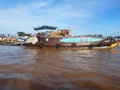 Detail of houses and floating boats in brown waters of the Mekong river. Floating market and Asian culture Royalty Free Stock Photo