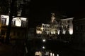 Detail of houses with silhouettes of abare trees with catkins at night in Ghent