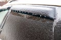 Frozen icicles after freezing rain on a car roof, selective focus, blurred green background Royalty Free Stock Photo